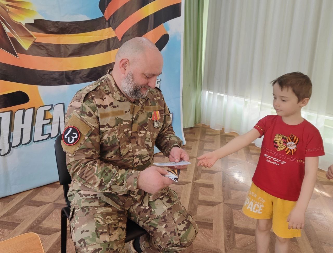 Сегодня в дошкольном отделении МБОУ СОШ №1 им. Героя Советского Союза И.И. Иванова (ул. Институтская, 2А) состоялась волнующая встреча с участником специальной военной операции, рядовым мотострелковых войск Павлом Викторовичем Костеневкиным. Павел Викторович рассказал ребятам о важном значении СВО, о любви к Родине и готовности защищать родных и близких. Он поделился историями о мужестве и героизме своих сослуживцев, рассказал, какими качествами должен обладать современный солдат и как важно преодолевать трудности войны. Настоящий герой нашего времени подчеркнул, что поддержка и вера в победу родных и всей страны помогают справиться со всеми трудностями на передовой и поддерживают боевой дух. Урок мужества прошел в теплой и дружеской обстановке. Ребята увидели на конкретном примере, что герои живут рядом, и что мужество, храбрость и любовь к Родине – это качества настоящего патриота и гражданина России. В завершение мероприятия дошкольники прочитали стихи о Родине и Дне Победы, передали на фронт открытки и письма, сделанные своими руками для наших бойцов.